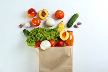 Bunch of mixed organic fruits, vegetables & greens, gourmet pile in full eco friendly shopping bag to reduce ecological footprint. Zero waste concept. White table background, copy space, close up.