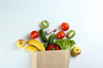 Bunch of mixed organic fruits, vegetables & greens, gourmet pile in full eco friendly shopping bag to reduce ecological footprint. Zero waste concept. White table background, copy space, close up.