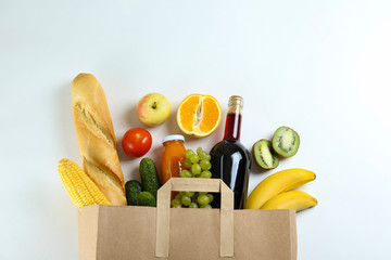 Bunch of mixed organic fruits, vegetables & greens, gourmet pile in full eco friendly shopping bag to reduce ecological footprint. Zero waste concept. White table background, copy space, close up.