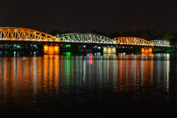 Colorful illuminated bridge over a river in Hue, Vietnam