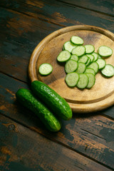 Whole and sliced cucumber on a wooden cutting board. Cucumber slices.