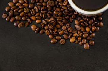 cup of coffee and coffee beans on a black background. Close-up. View from the top. Place for text.