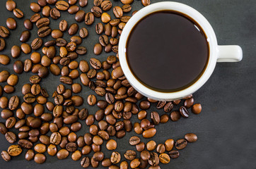 cup of coffee and coffee beans on a black background. Close-up. View from the top.