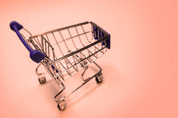 Shopping cart on a pink background. Concept festive sale online, Christmas and New Year discounts, level of consumer basket, black friday. Copy space.