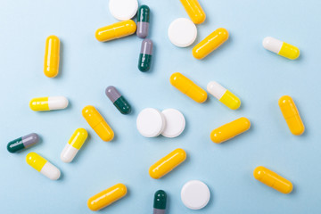 Multicolor tablets and pills capsules on blue background Heap of assorted various medicine tablets and pills. Health care Close-up Copy space