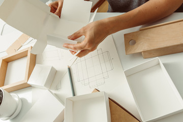 The designer creates a mockup for crafting of cardboard ecological packaging. Development a model...