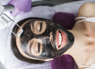 Cute Korean woman gets a face peeling procedure in a beauty salon. Skin care