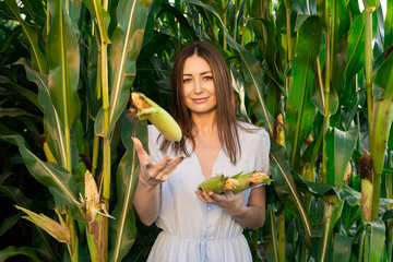 Brunette in blue dress throws corn and smiles