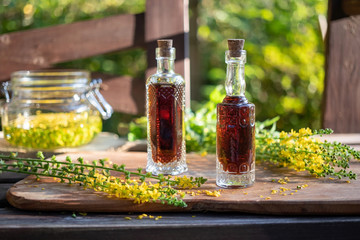 Bottles of agrimony tincture with fresh agrimony plant