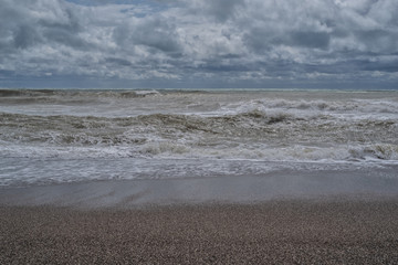 Desert sandy beach, gray sky and clouds, autumn cloudy sky