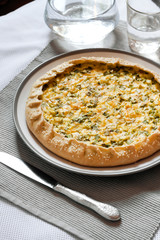 Tart with eggs and green onions on a plate