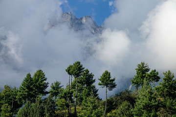 CLOSE UP: Scenic view of white clouds obstructing the view of rocky mountains