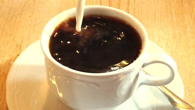 Milch Splash in Kaffee Tasse Nahaufnahme