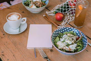 Notebook and meals on wooden table