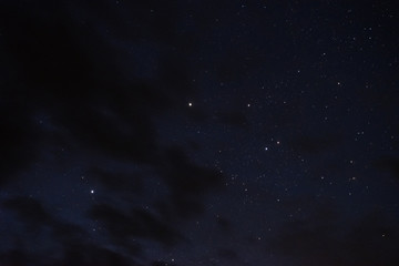 Obraz na płótnie Canvas Stars in the night sky through the clouds