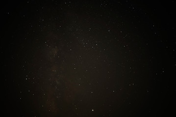 Night starry sky and man with lamp. Long exposure photography.
