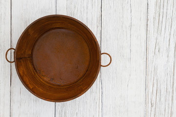 Rusted tin pail on weathered whitewash textured wood background