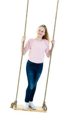 Beautiful teen school girl swinging on a swing. Concept summer v