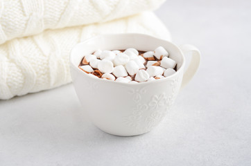 Fototapeta na wymiar Cup of hot chocolate with marshmallows on a gray concrete background. 