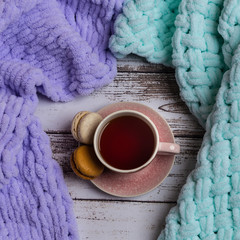 Variation of plaids on wooden table with cup of tea.