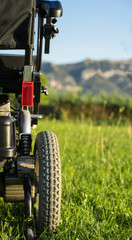 wheelchair on Grass with sky in the background, vertical image