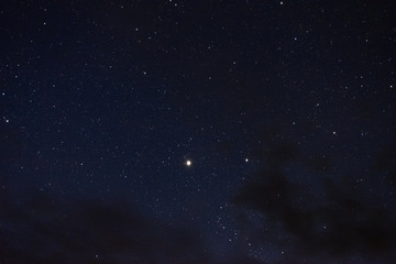 Stars in the night sky through the clouds
