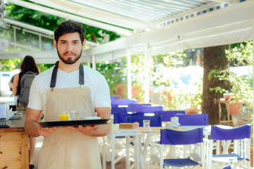 Young waiter holding tray.
