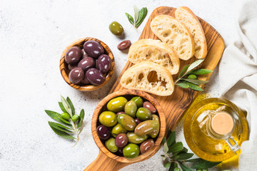 Olives, ciabatta and olive oil on white background.