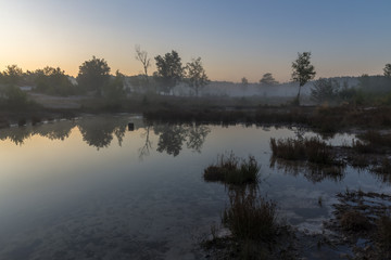 Brunsummerheide (translation Brunssumer meadows) a national park in South Limburg in the Netherlands with morning fog over the swamp during sunrise