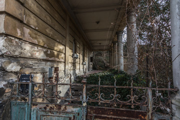 verlassene villa mit saeulen und gartentor