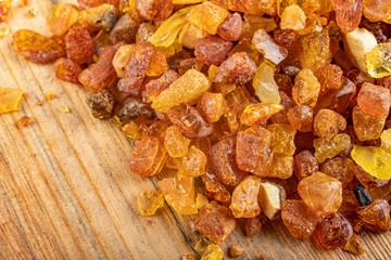 Small raw amber on a wooden table. A precious find from the coast of Central Europe.