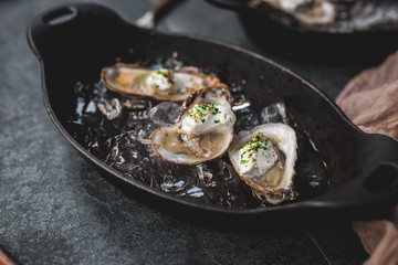 Raw oyster with mignonette sauce, celery & cream in cast iron on ice