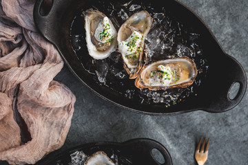 Raw oyster with mignonette sauce, celery & cream in cast iron on ice
