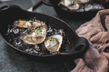 Raw oyster with mignonette sauce, celery & cream in cast iron on ice