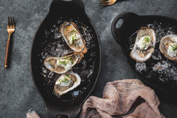 Raw oyster with mignonette sauce, celery & cream in cast iron on ice