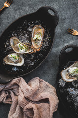 Raw oyster with mignonette sauce, celery & cream in cast iron on ice