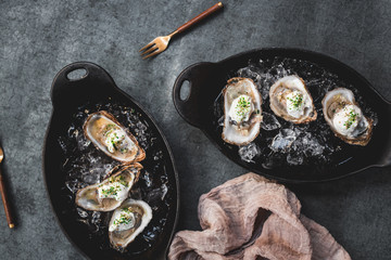 Raw oyster with mignonette sauce, celery & cream in cast iron on ice