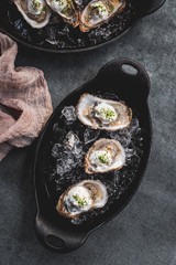 Raw oyster with mignonette sauce, celery & cream in cast iron on ice