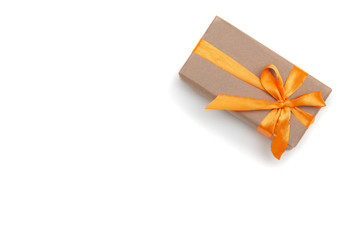 gift box on white background copy space top view golden ribbon with bow wrapped in brown paper