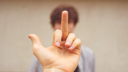 showing a middle finger to the person. disrespect sign