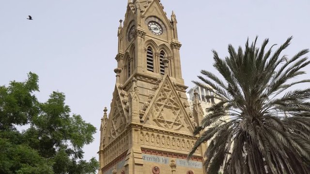 Karachi Merewether Clock Tower Low Angle Side View at JInnah Road with Flying Birds on a Cloudy Day