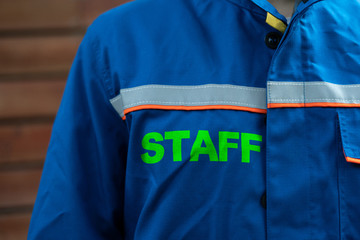 close up  man person in uniform with word "staff" on it
