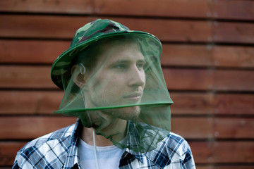 a traveler man in the mosquito mask to protect face from insects
