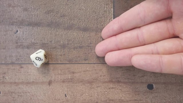 Rolling a 9 on a 10 sides dice. Birdseye view, closeup 4k, slow motion.