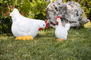 Two White decoration hens on green grass