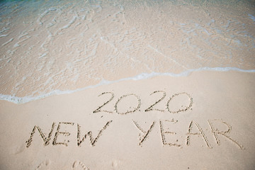 Happy New Year written in the white sand