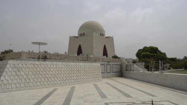 Karachi Mazar-e-Quaid Jinnah Mausoleum Frontal View with Empty Fountain and Flying Birds on a Cloudy Day