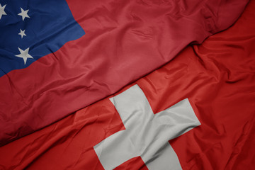 waving colorful flag of switzerland and national flag of Samoa .
