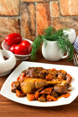Baked chicken legs with carrots and mushrooms.