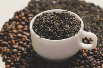 Cup with tea and coffee grains on wooden table